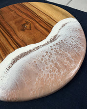 Close-up of beige / neutral  ocean wave resin on square cheeseboard