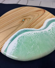 Close-up of mint green ocean wave resin on square cheeseboard