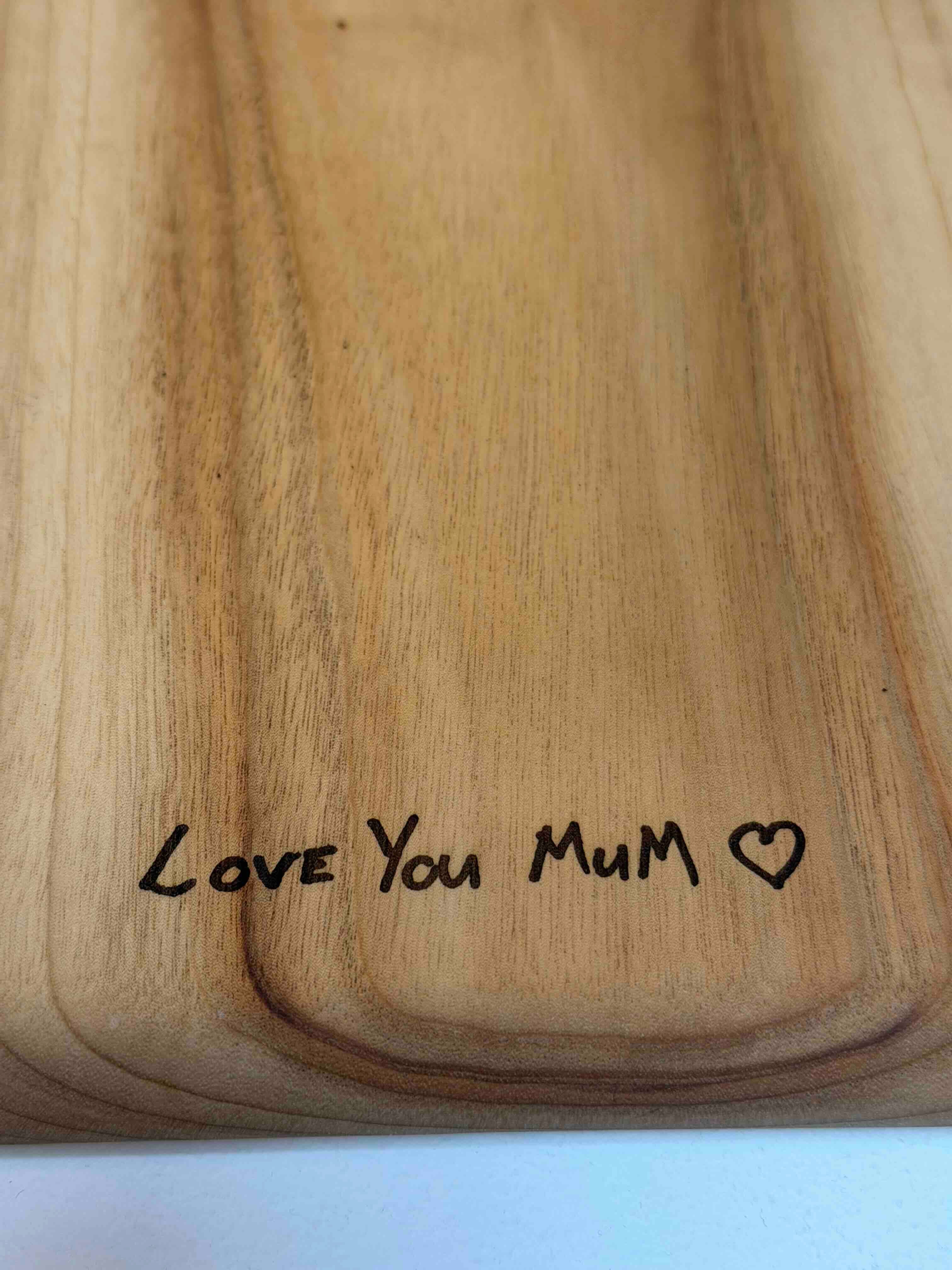 Wooden board engraved with the text Love You Mum and a heart symbol