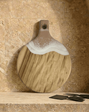 A round paddle board in the neutral coloured resin shot in against a kitchen splashback