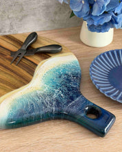 A round paddle board in the beach coloured resin shot on a kitchen table, a close up showing the detail of the resin waves