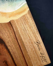 Resin wooden cutting board with 'Barn Hill' engraving on a dark background