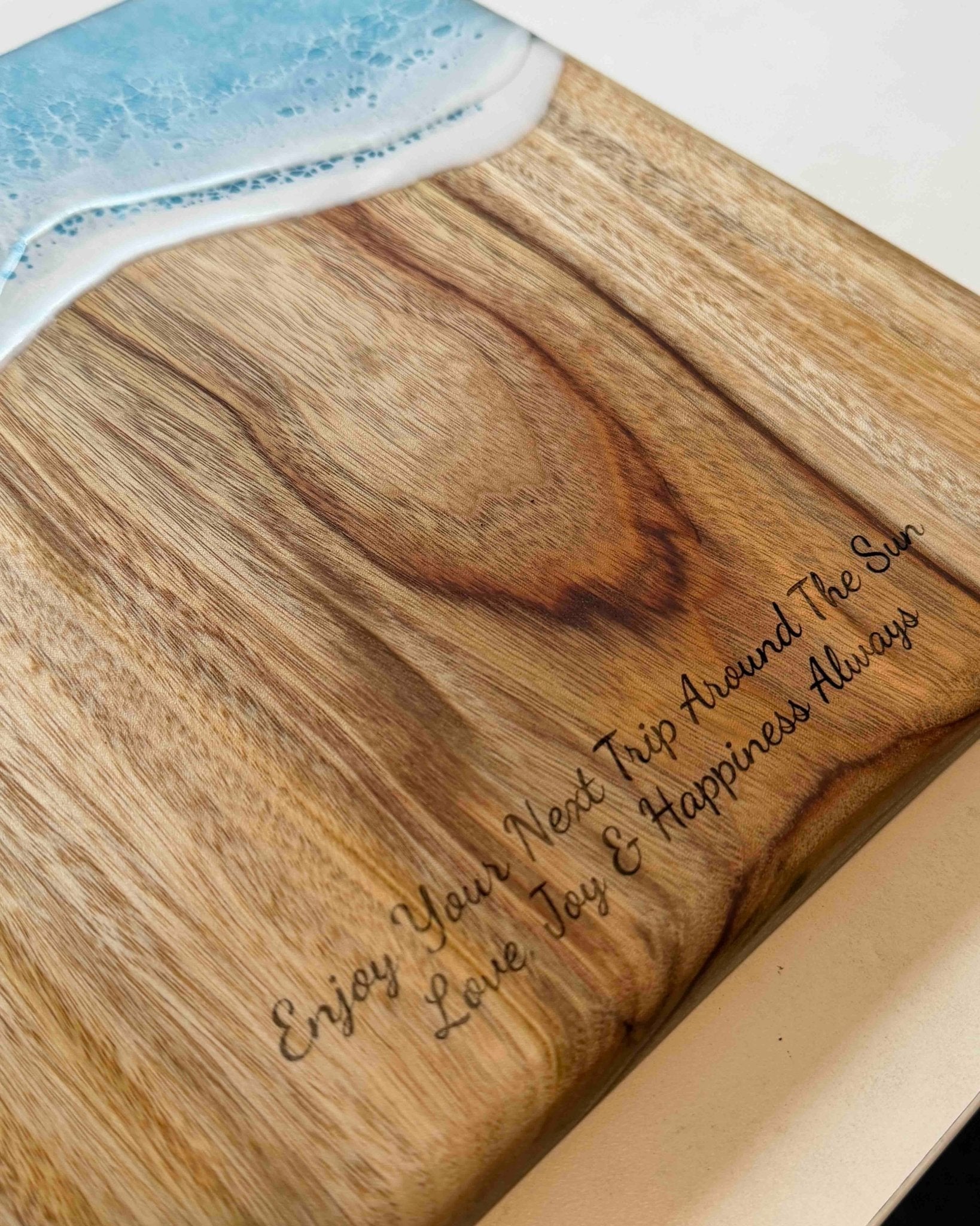 Camphor laurel timber cutting board with engraved text on a white surface
