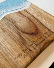 Camphor laurel timber cutting board with engraved text on a white surface