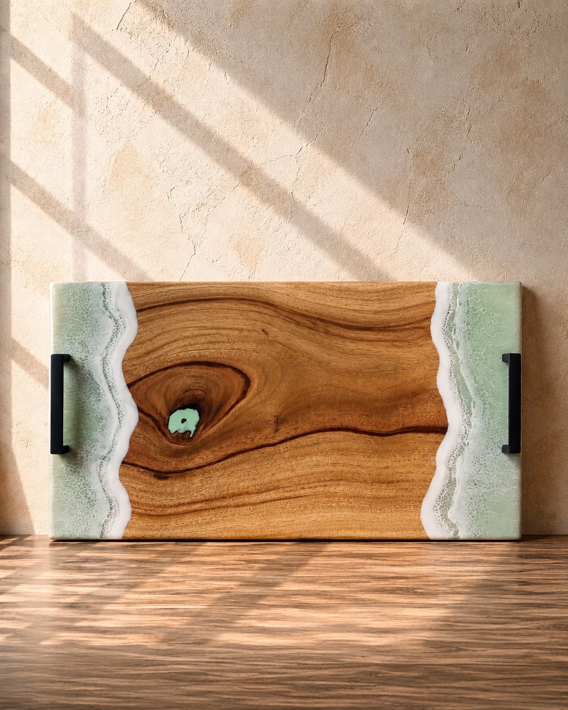 Wooden serving board with mint and white resin waves on the edges on a wooden surface